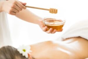 Woman having massage with honey Auftragen von Honig auf dem Rücken bei Honigmassage